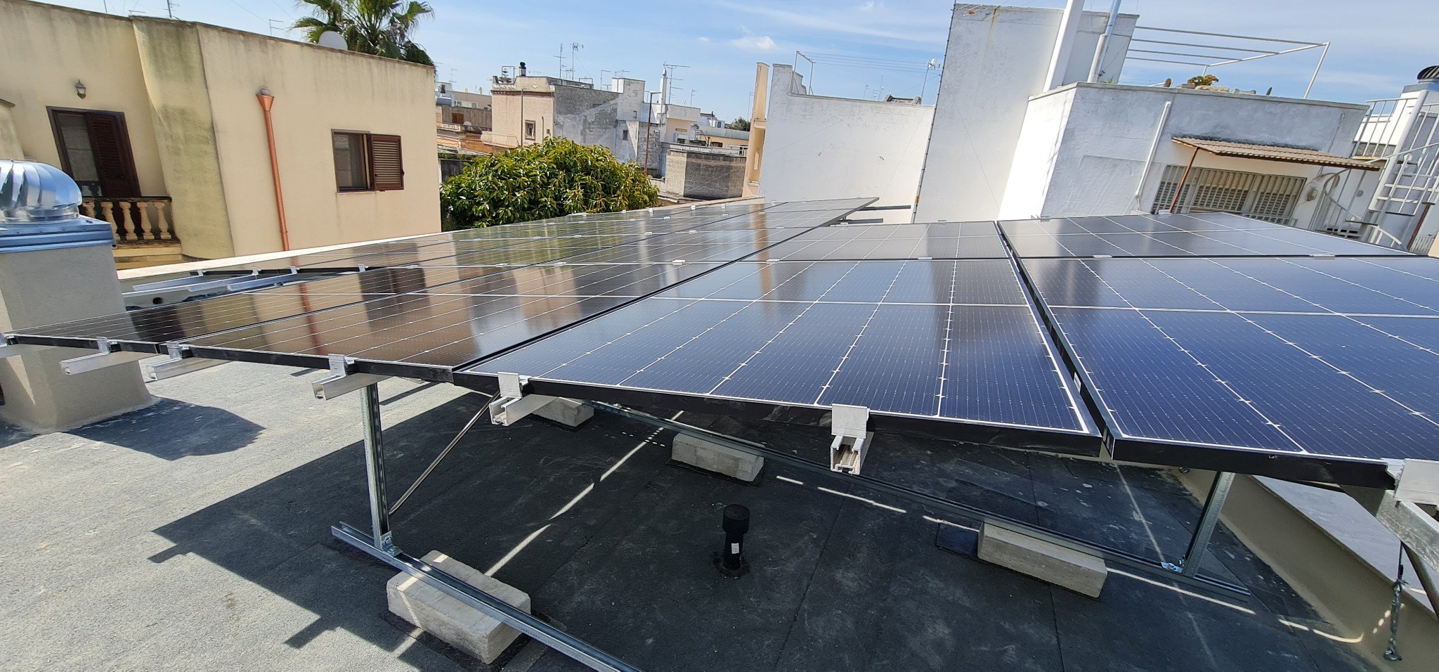 Pannelli fotovoltaici su struttura inclinata con zavorre su tetto piano