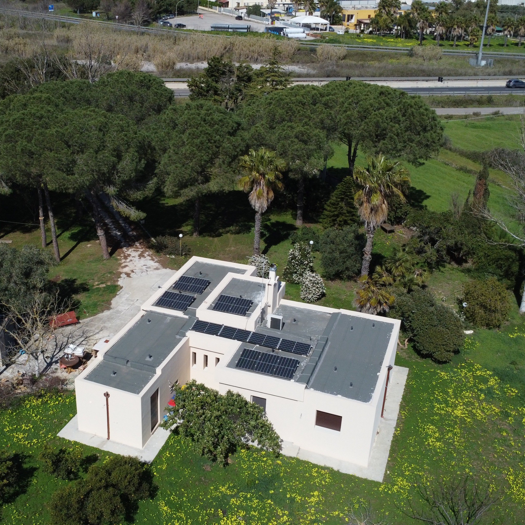 Vista aerea di villa immersa nel verde con pannelli fotovoltaici
